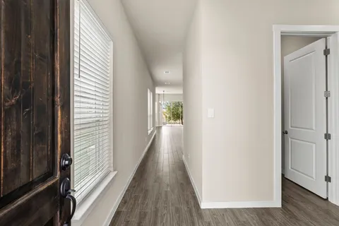 a view of a hallway with wooden floor