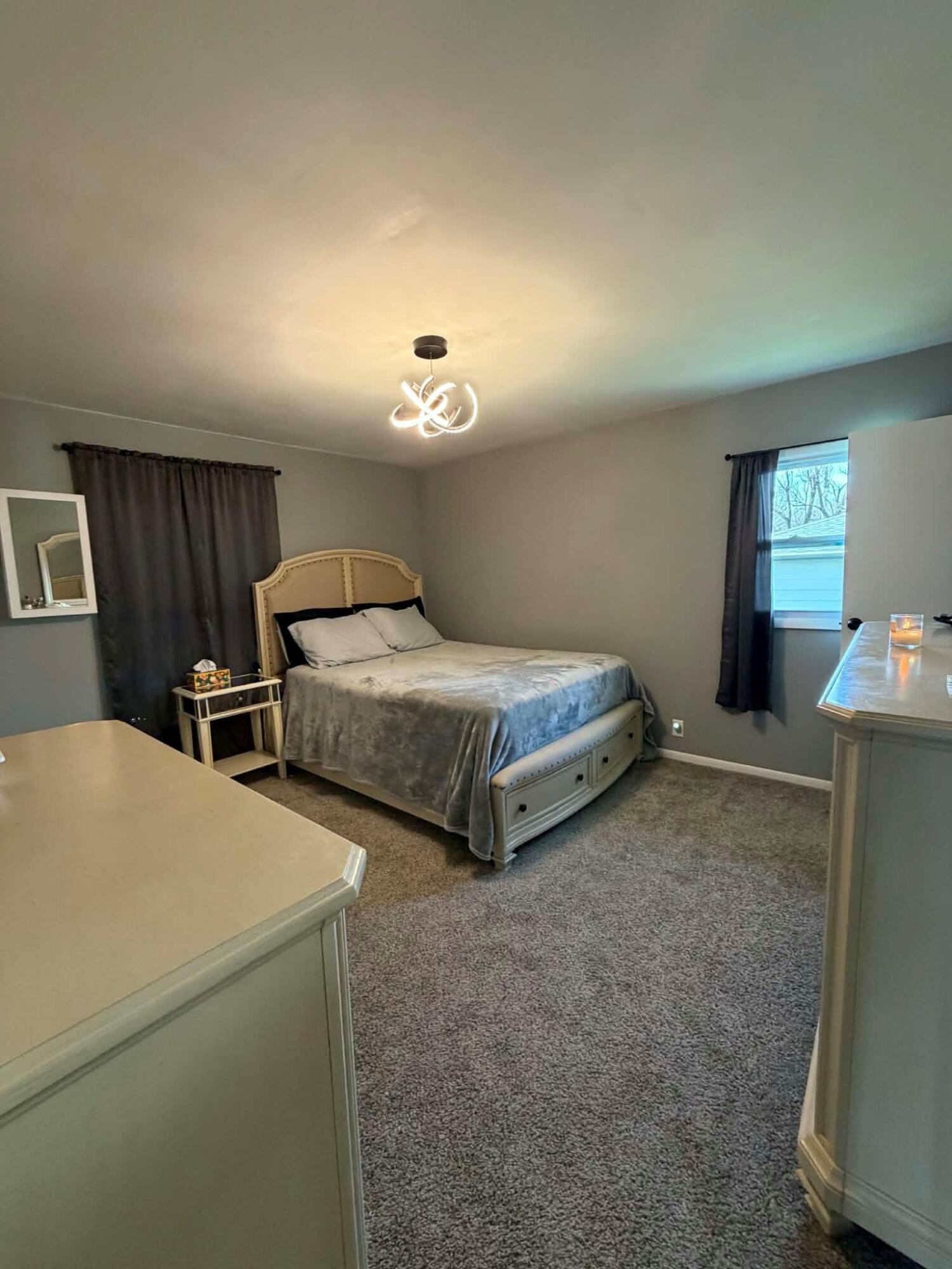 716 East Stewart Drive Rensselaer, IN 47978 - Photo 9 of 22 a spacious bedroom with two bed and a chandelier