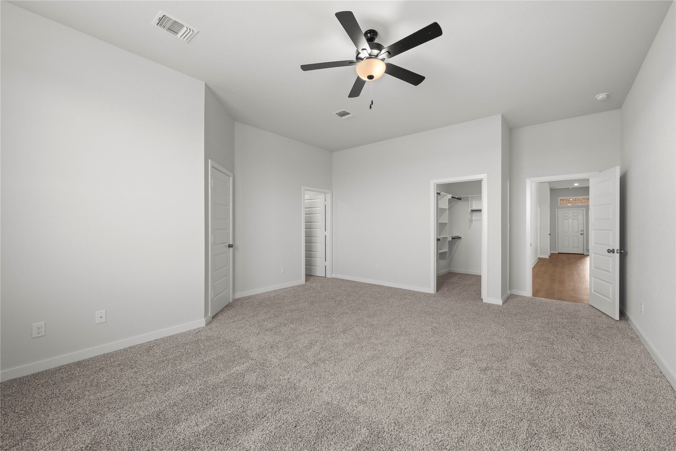 220 Gus Loop Georgetown, TX 78626 - Photo 12 of 18 A quiet bedroom featuring plush carpeting, a practical ceiling fan, and convenient walk-in closet access.
