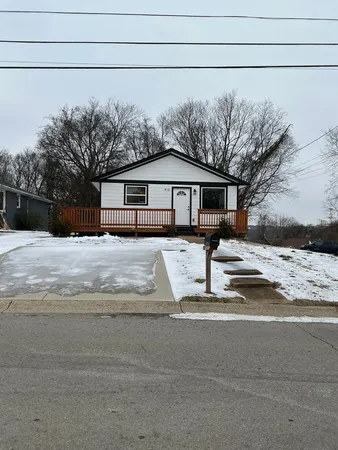 a view of a house with snow on the road