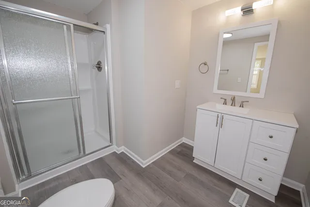 a bathroom with a sink a toilet and shower