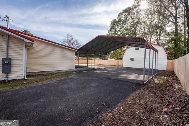 a view of backyard with a barn and large trees