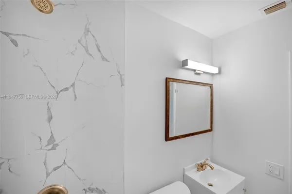 a white toilet sitting next to a bathroom sink