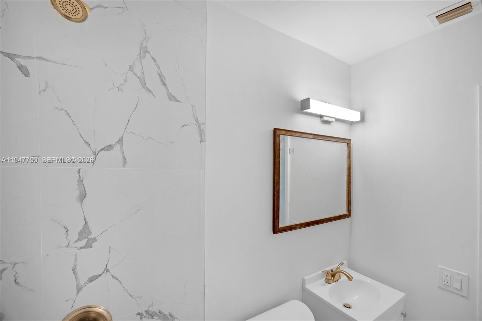 2530 Southwest 16th Terrace, Unit 1 Miami, FL 33145 - Photo 15 of 48 a bathroom with a small white wall and a shower