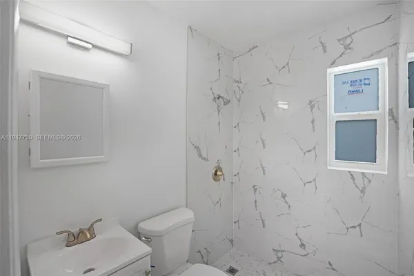 a view of a room with a ceiling fan and a window