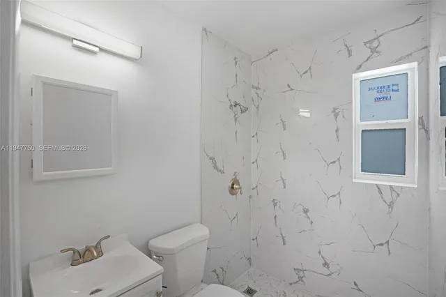 a view of a room with a ceiling fan and a window