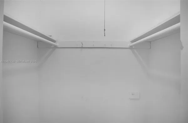 a view of a big room with wooden floor closet and windows in a room