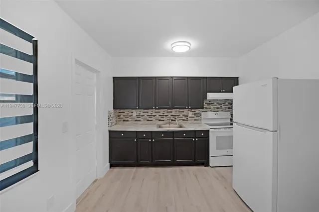 a view of kitchen with stainless steel appliances granite countertop cabinets and stove top oven