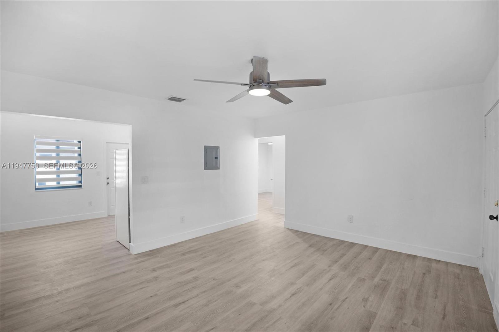 2530 Southwest 16th Terrace, Unit 1 Miami, FL 33145 - Photo 47 of 48 an empty room with wooden floor chandelier fan and windows