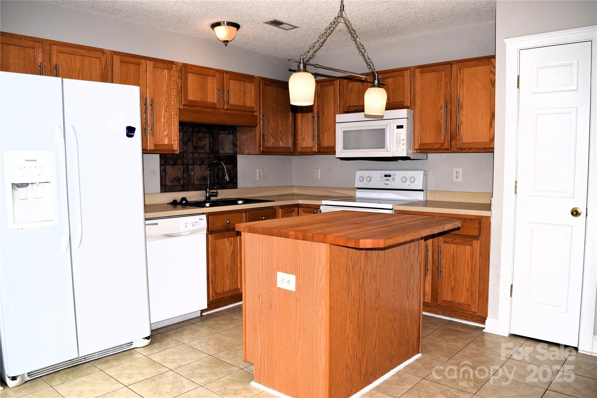 13840 Hastings Farm Road Huntersville, NC 28078 - Photo 12 of 32 a kitchen with stainless steel appliances granite countertop a sink a refrigerator and a microwave