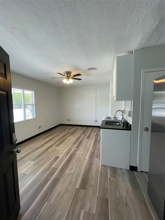 707 Rosery Road Northwest, Unit 3 Largo, FL 33770 - Photo 3 of 10 a kitchen with granite countertop a stove and a refrigerator