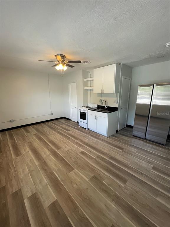 707 Rosery Road Northwest, Unit 3 Largo, FL 33770 - Photo 4 of 10 a view of a kitchen with a sink cabinets and a ceiling fan