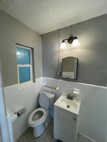 a bathroom with a toilet sink and mirror