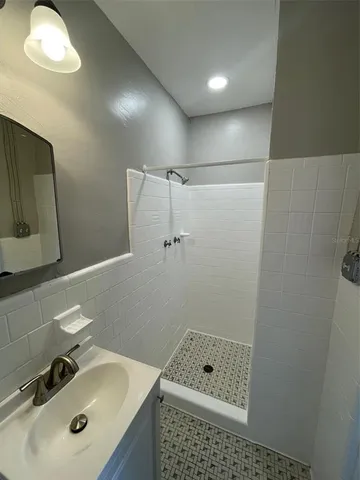 a bathroom with a sink a shower and mirror