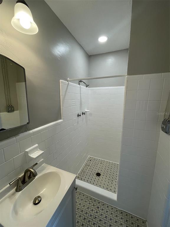 707 Rosery Road Northwest, Unit 3 Largo, FL 33770 - Photo 8 of 10 a bathroom with a sink a shower and mirror