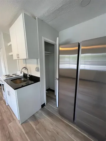 a kitchen with granite countertop a sink and a refrigerator