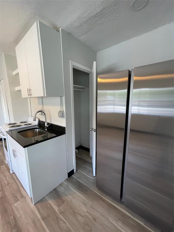 707 Rosery Road Northwest, Unit 3 Largo, FL 33770 - Photo 10 of 10 a kitchen with granite countertop a sink and a refrigerator