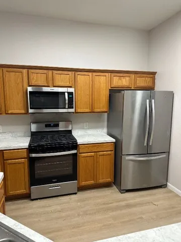 a kitchen with granite countertop a stainless steel stove and refrigerator