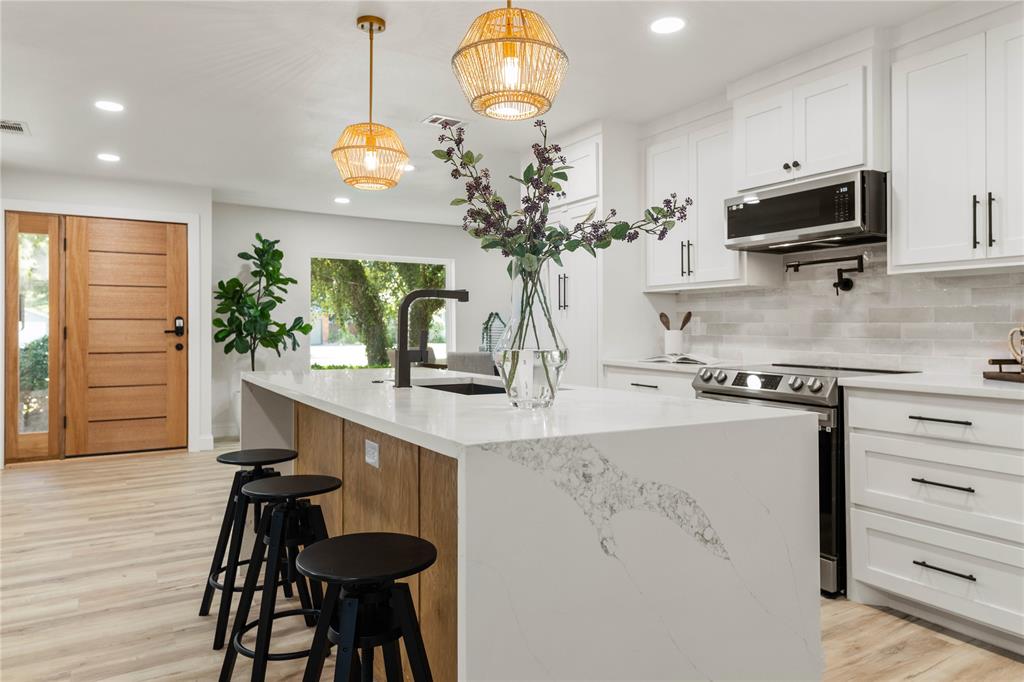 a kitchen with kitchen island a counter space a stove and a wooden floor