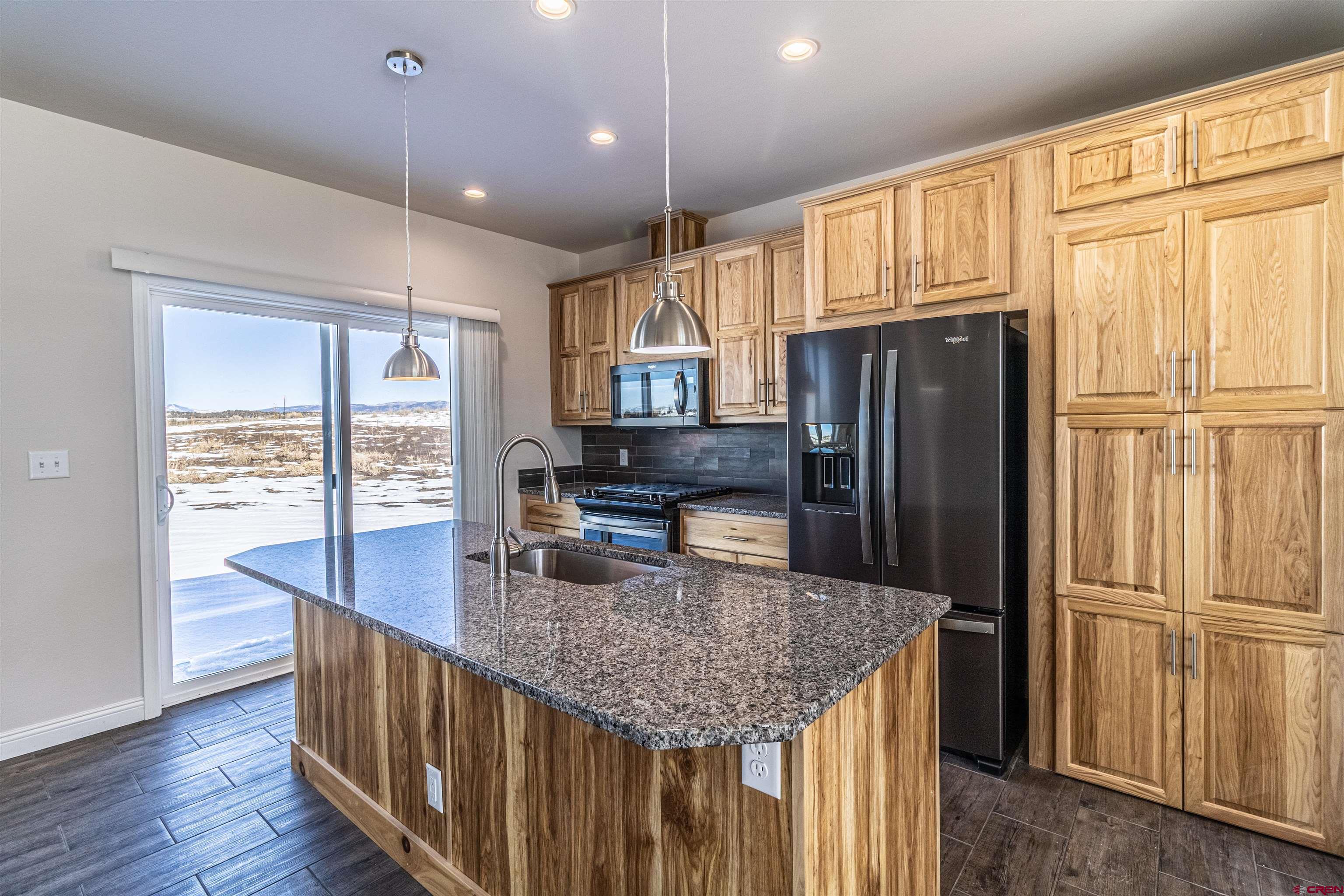 200 Chesterfield Place Ignacio, CO 81137 - Photo 12 of 35 a kitchen with stainless steel appliances granite countertop a refrigerator a sink and a center island