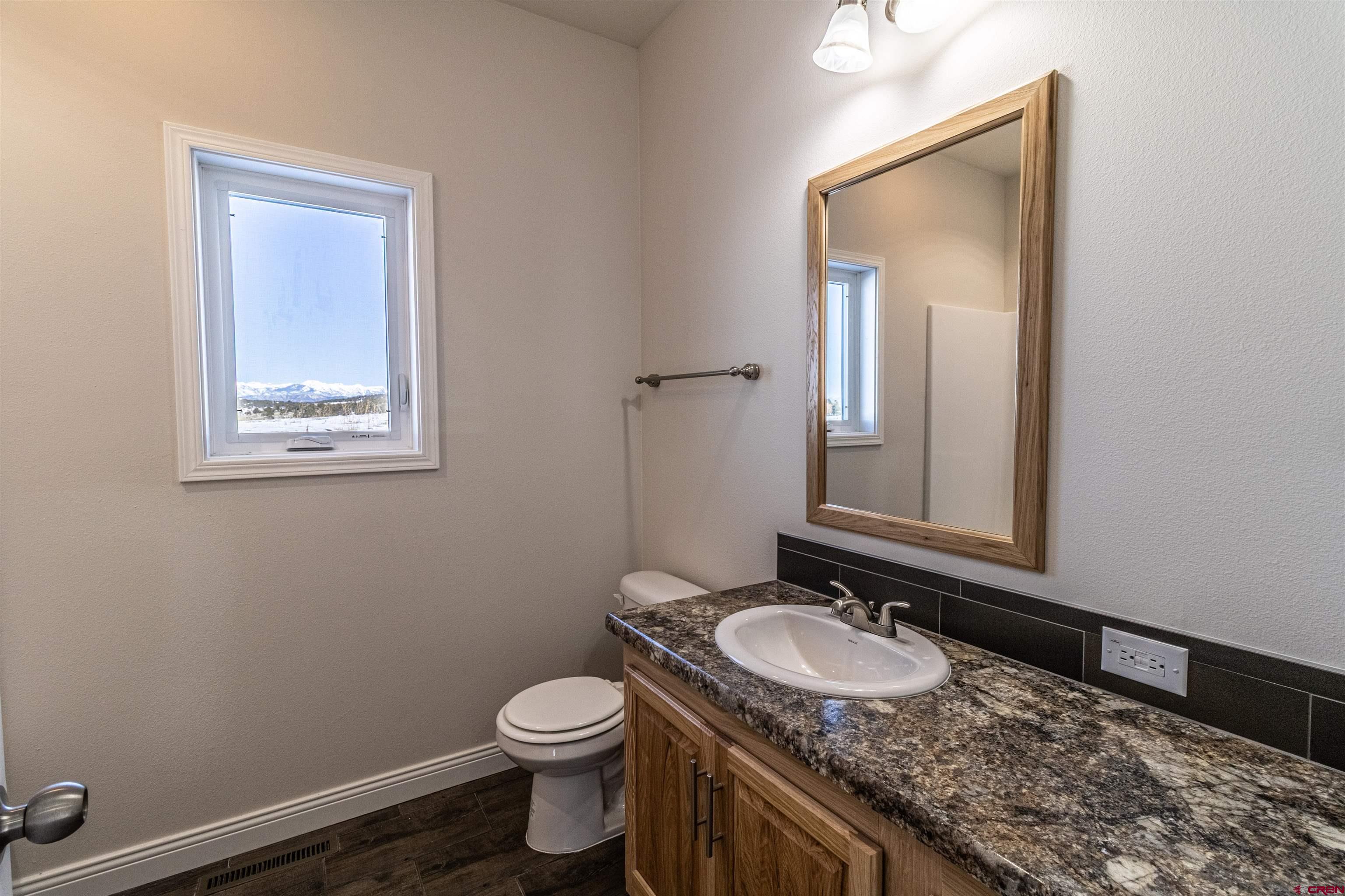 200 Chesterfield Place Ignacio, CO 81137 - Photo 21 of 35 a bathroom with a granite countertop toilet sink and mirror