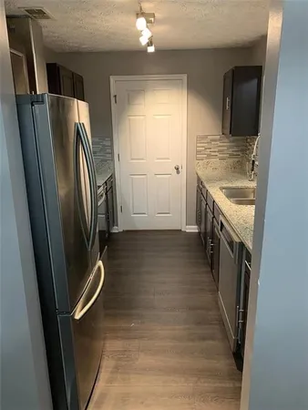 a view of a refrigerator in kitchen and a sink