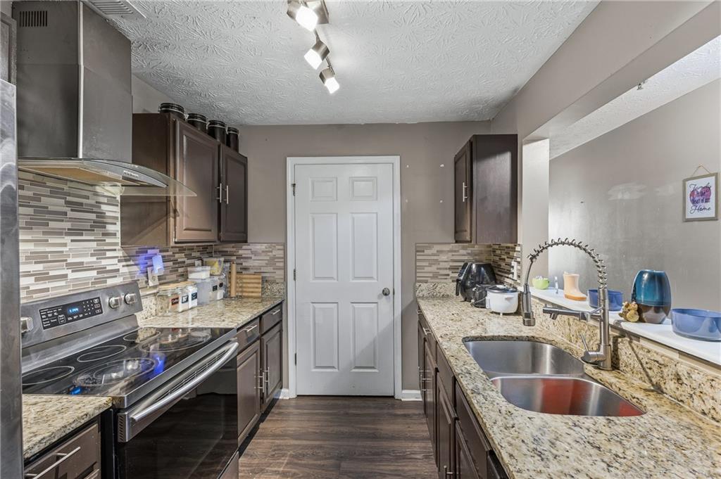 6203 Fairington Ridge Circle Stonecrest, GA 30038 - Photo 6 of 13 a kitchen with kitchen island granite countertop a sink stove and refrigerator
