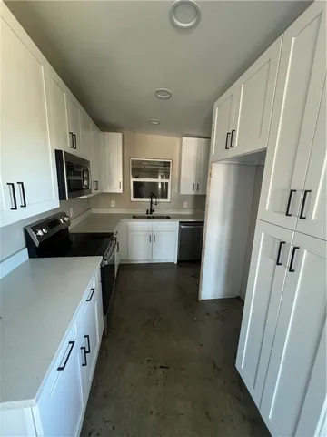 a kitchen with a refrigerator a stove top oven a sink dishwasher and wooden cabinets