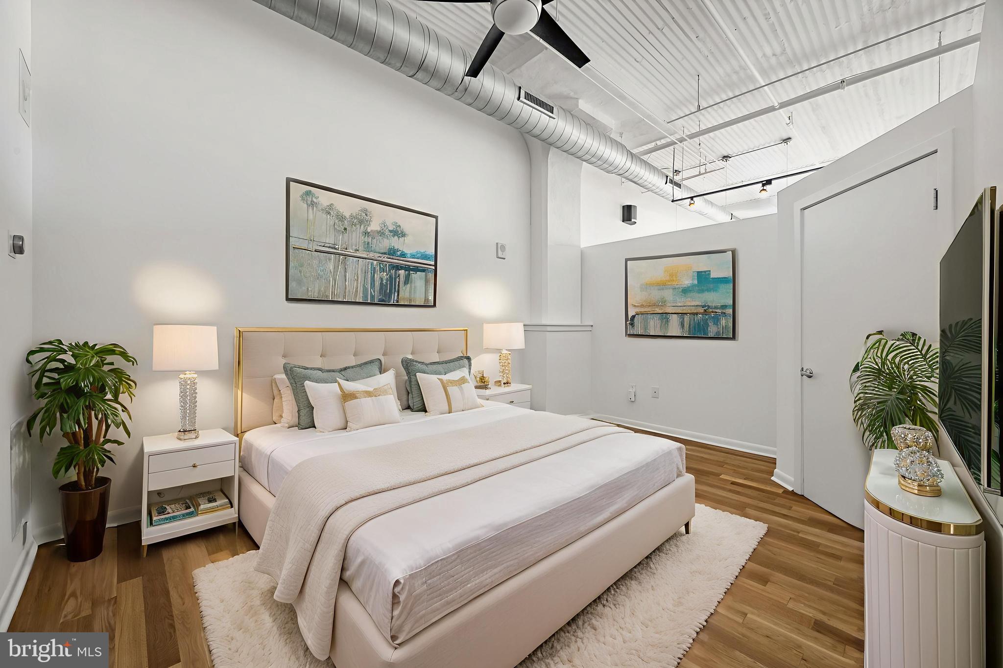 2200-28 Arch Street, Unit 716 Philadelphia, PA 19103 - Photo 11 of 35 a bedroom with a large bed a potted plant and dresser