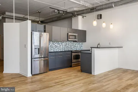 a kitchen with stainless steel appliances granite countertop a refrigerator and a stove
