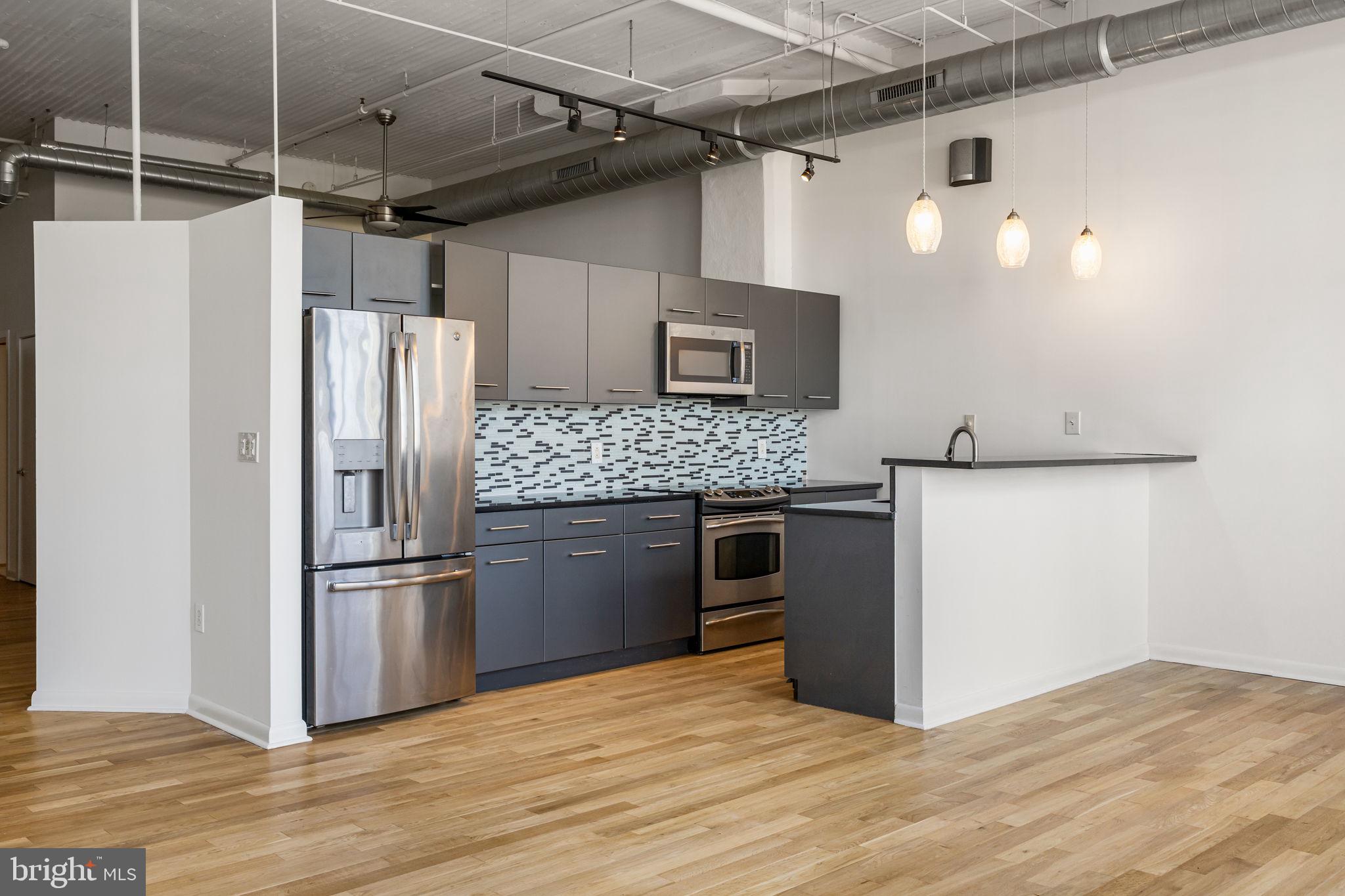 2200-28 Arch Street, Unit 716 Philadelphia, PA 19103 - Photo 5 of 35 a kitchen with stainless steel appliances granite countertop a refrigerator and a stove