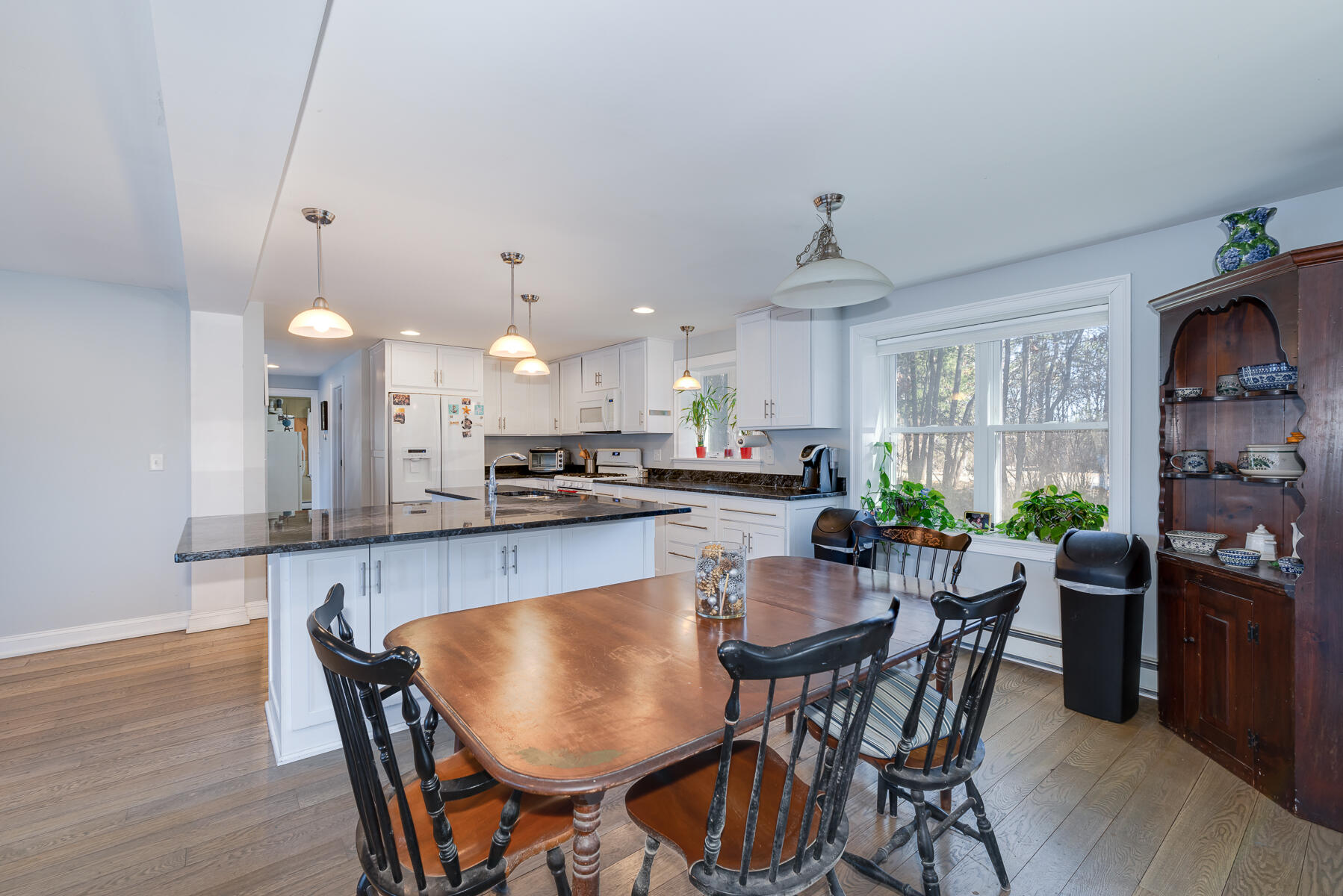65 Santuit Lane Mashpee, MA 02649 - Photo 14 of 52 a dining room with kitchen island a chandelier dining table and chairs