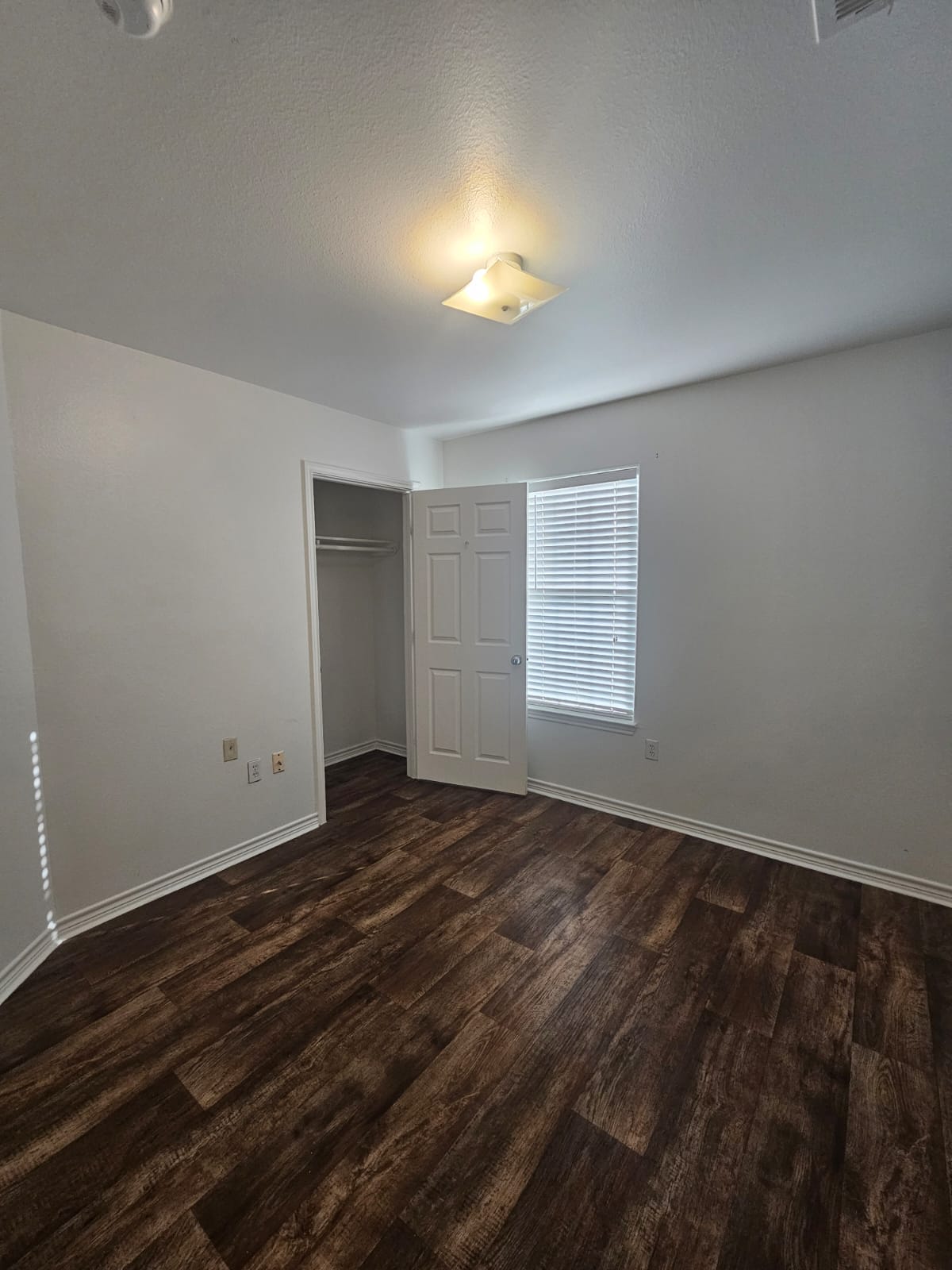 606 Trinity Street Lockhart, TX 78644 - Photo 9 of 23 Well-lit room with wood flooring and a closet, perfect for a peaceful retreat.