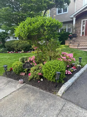 a view of a garden with a lot of flower plants and wooden fence
