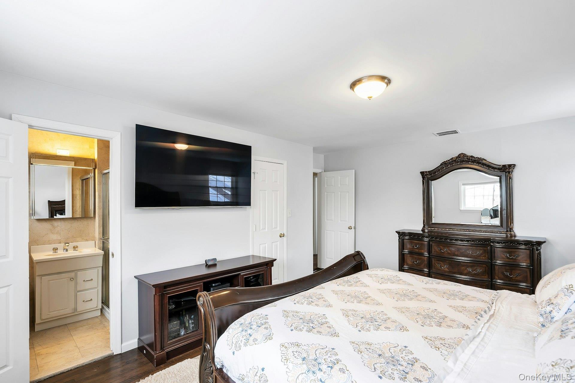 2043 Ripley Lane Merrick, NY 11566 - Photo 21 of 37 a bedroom with a bed and a flat screen tv