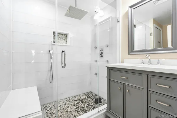 a bathroom with a sink a toilet a shower and a mirror