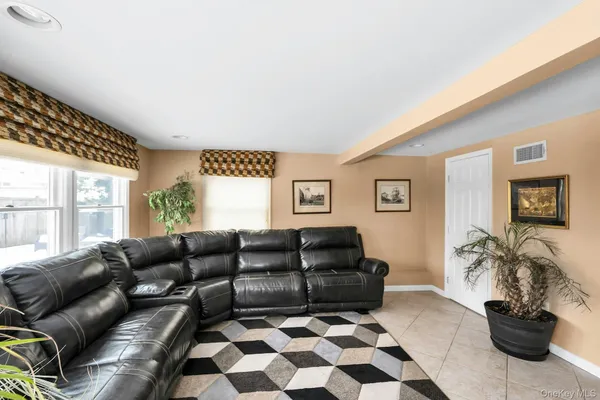 a living room with a couch and a potted plant