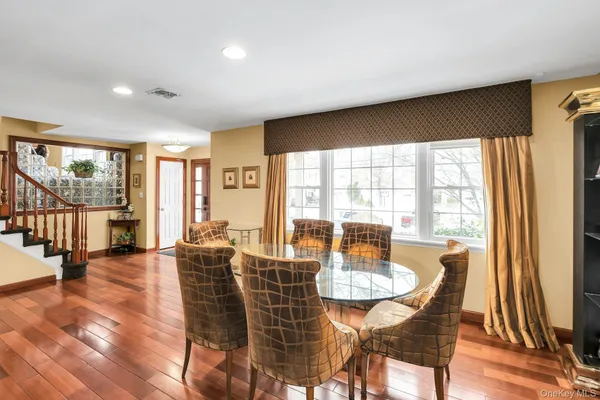 a dining room with furniture window and wooden floor