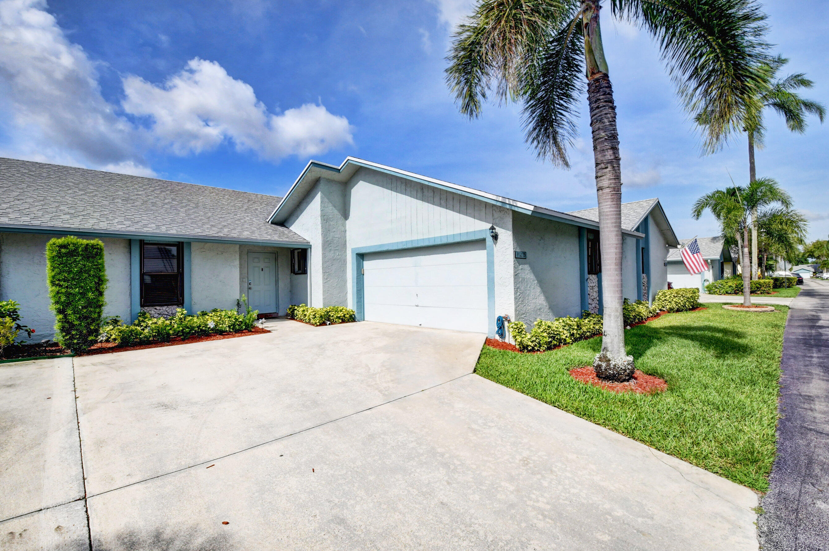 9142 Southwest 22nd Street, Unit D Boca Raton, FL 33428 - Photo 1 of 36 a front view of a house with a yard and garage
