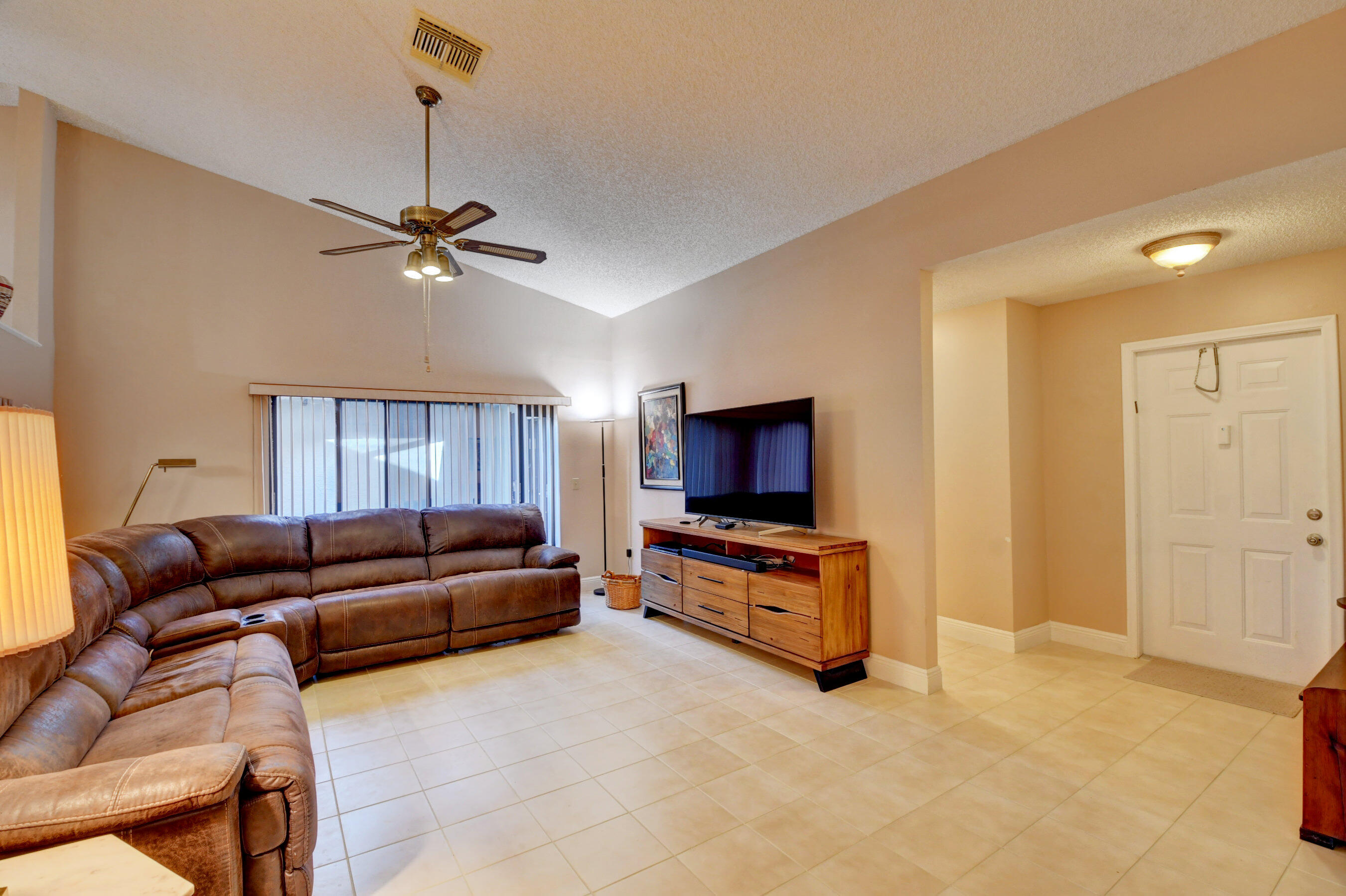 9142 Southwest 22nd Street, Unit D Boca Raton, FL 33428 - Photo 3 of 36 a living room with furniture and a flat screen tv
