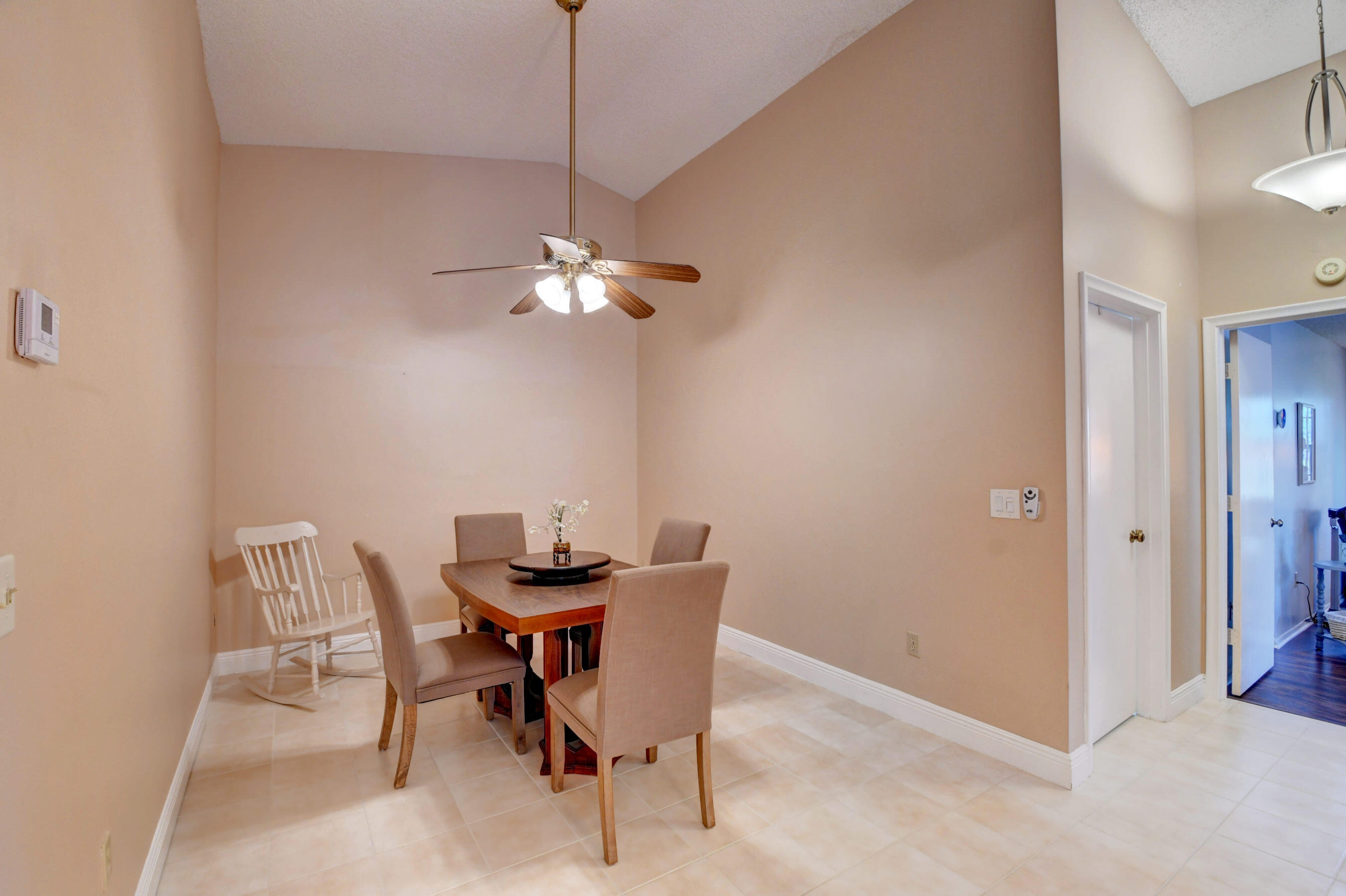 9142 Southwest 22nd Street, Unit D Boca Raton, FL 33428 - Photo 7 of 36 a dining room with furniture and chandelier
