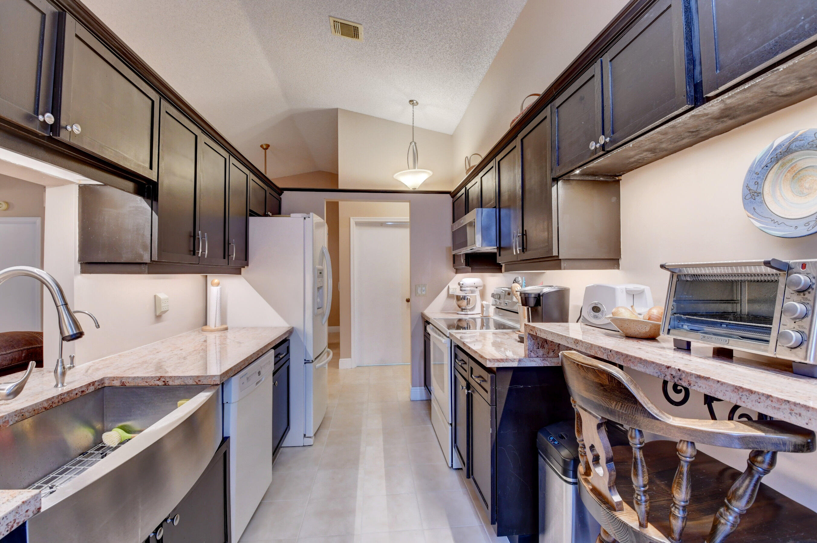 9142 Southwest 22nd Street, Unit D Boca Raton, FL 33428 - Photo 8 of 36 a kitchen with stainless steel appliances granite countertop a sink a stove and a refrigerator