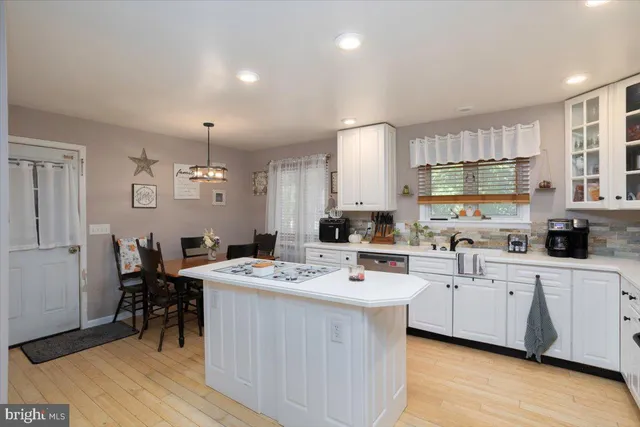 a kitchen with a sink a counter top space stainless steel appliances and cabinets