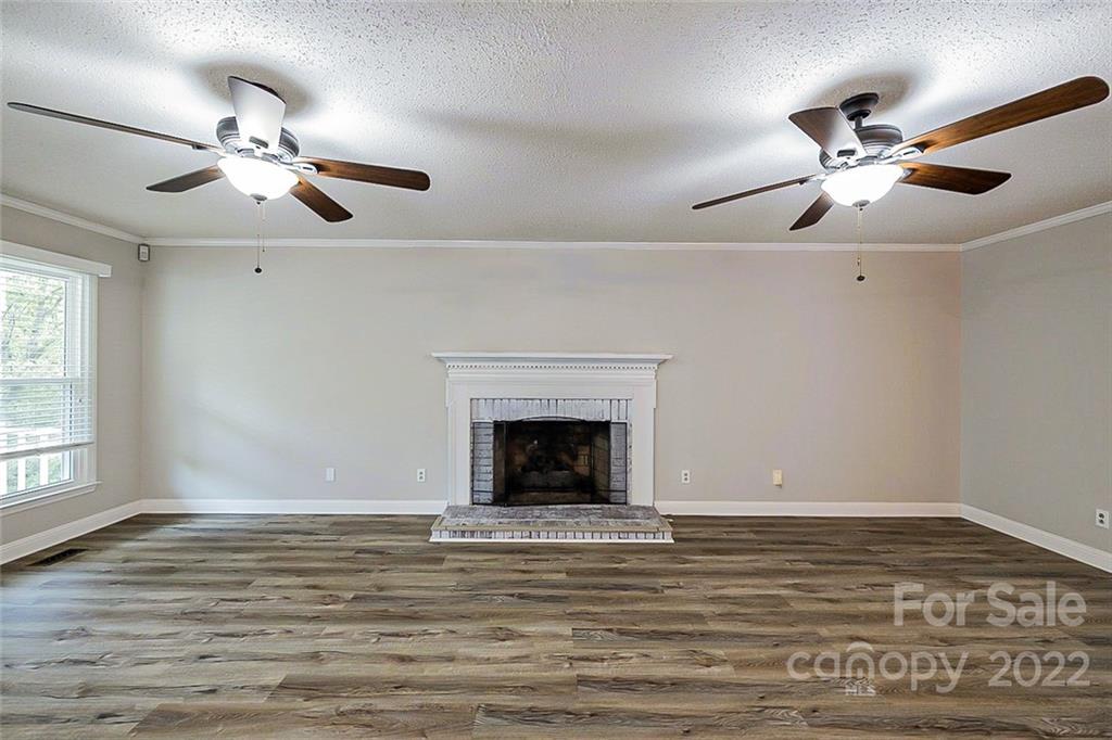 2927 Trotters Road Gastonia, NC 28054 - Photo 2 of 16 a view of a livingroom with a ceiling fan fireplace and wooden floor