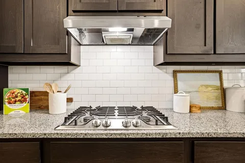 a kitchen with granite countertop a stove and a sink