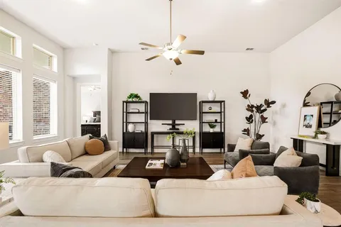 a living room with furniture flat screen tv and a large window