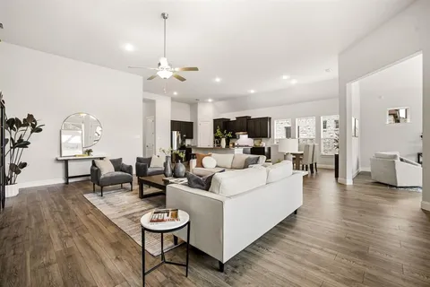 a living room with furniture a dining table and chairs with wooden floor
