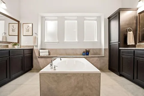 a bathroom with a tub sink and mirror
