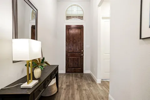a view of a hallway and dining room with wooden floor