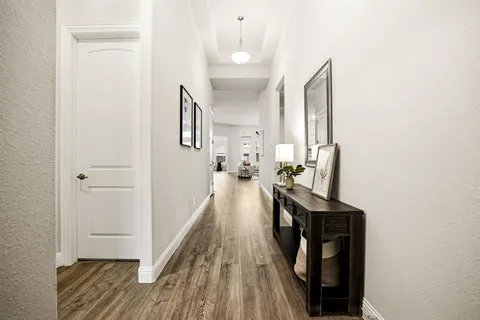 a view of a hallway with wooden floor and staircase